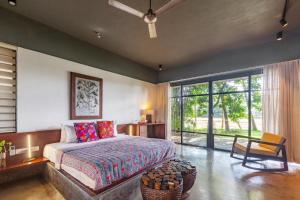 a bedroom with a bed and a large window at StayVista at Toya Toya River View in Kozhikode