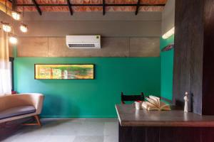 a green wall in a room with a desk at StayVista at Toya Toya River View in Kozhikode