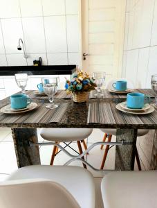 einen Tisch mit 2 Stühlen und einen Tisch mit Tellern und Gläsern in der Unterkunft Apê Serrano in Serra de São Bento