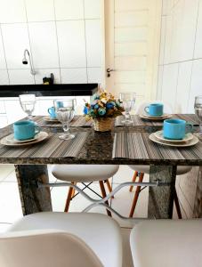 a table with two chairs and a table with plates and glasses at Apê Serrano in Serra de São Bento +8 photos