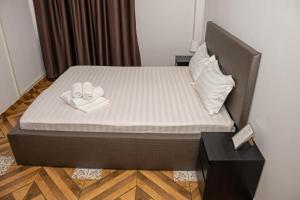 Occidental Wise Transit Hotel في بوخارست: سرير في غرفة عليها منشفتين