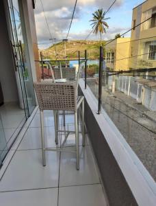 balcón con 2 sillas y vistas a la calle en Apê Serrano en Serra de São Bento