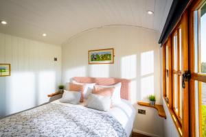 a bedroom with a bed with white sheets and a window at The Shepherds Retreat - Ockeridge Rural Retreats in Wichenford
