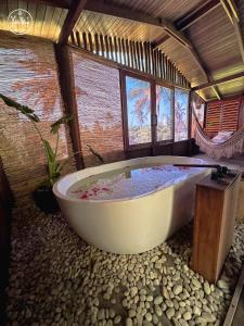 a large bath tub in a room with windows at Aloha Village Bangalôs in Icaraí