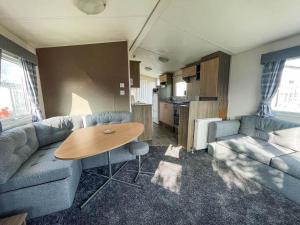 a living room with a couch and a table at Homely Dog Friendly Caravan At California Cliffs Holiday Park, Ref 50024j in Great Yarmouth