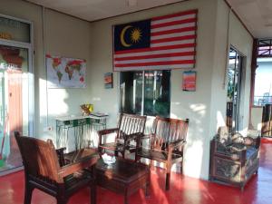 una habitación con sillas y una bandera americana en la pared en Bohok Guesthouse, en Pantai Cenang