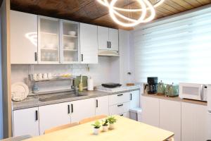 a kitchen with white cabinets and a table at Aiola Cine Hongdae in Seoul