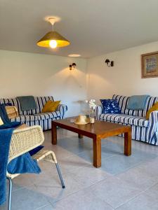 una sala de estar con sofás de rayas azules y blancas y una mesa. en CÔTE VILLAGE, en Quiberville