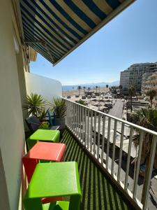 uma varanda com cadeiras coloridas e vista para a praia em MAGNIFIQUE VUE MER Place Centrale F2 45 m2 tout confort Travaux en cours sur façade em Canet-en-Roussillon