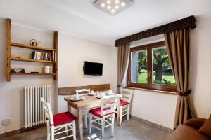 uma sala de jantar com uma mesa e cadeiras e uma janela em La Vigne De Papagran App1 em Aosta