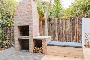un horno de ladrillo sentado en un patio junto a una valla en 7 Pepper Street by African Perfection, en Jeffreys Bay