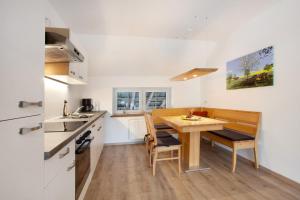 eine kleine Küche mit einem Holztisch und Stühlen in der Unterkunft Ferienwohnungen Übern Hof in Schmallenberg