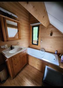 La grande salle de bains est pourvue d'une baignoire et d'un lavabo. dans l'établissement Le chalet du Cerf - Chambres d'hôtes, à Somme-Leuze