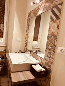 La salle de bains est pourvue d'un lavabo et d'un grand miroir. dans l'établissement Appio Latino Casa by Bobo, à Rome
