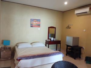 Un dormitorio con una cama, una cómoda y un espejo. en Bohok Guesthouse, en Pantai Cenang