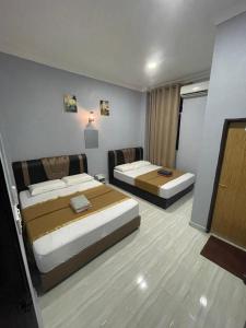 a hotel room with two beds and a television at Perhentian Suria in Perhentian Island