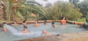 a group of people in a swimming pool at The Garden Under The Moon in Al Ḩayz