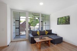 ein Wohnzimmer mit Sofa und Tisch in der Unterkunft Ferienwohnungen Übern Hof in Schmallenberg