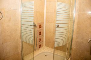 a shower with a glass door in a bathroom at Occidental Wise Transit in Bucharest