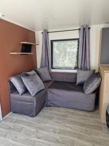 a living room with a couch and a window at Camping Les P'tites Maisons dans la Prairie in Sallertaine