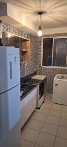 Il comprend une cuisine équipée d'un réfrigérateur blanc et d'une cuisinière. dans l'établissement Pedacinho de Lar, à João Pessoa