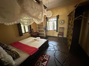 a bedroom with a bed and two windows at Kongo Dream in Diani Beach +35 photos