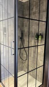 une porte de douche en verre avec un tuyau dans l'établissement Park Lane Rooms, à Abergavenny