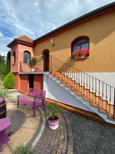 uma casa com um banco roxo e uma varanda em Sebe apartments 2 em Holíč