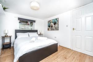 a bedroom with a large bed with white sheets at Lovely 2 Bedroom in Lower Clapton in London