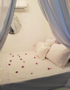ケリビアにあるDar Ginoのカーテン付きの花のベッド