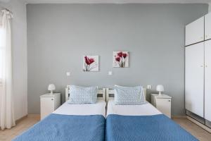 two beds in a bedroom with blue and white at Angelos Seaview Studios by Konnect, Kommeno Corfu in Kommeno