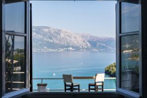 a room with two chairs and a view of a lake at Angelos Seaview Studios by Konnect, Kommeno Corfu in Kommeno