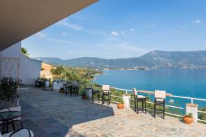 eine Terrasse mit Stühlen und Blick auf das Wasser in der Unterkunft Angelos Seaview Studios by Konnect, Kommeno Corfu in Kommeno