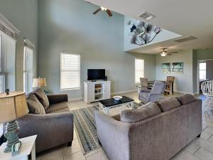 a living room with two couches and a tv at Sandy Starfish in Port Aransas