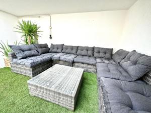 a living room with a sectional couch and a table at Baleal Happiness Surf House in Ferrel