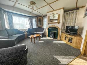 a living room with a couch and a tv at Spacious Caravan For Hire In Hunstanton At Manor Park Holiday Park Ref 23047b in Hunstanton