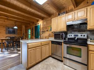 a kitchen with wooden cabinets and a stove top oven at Bear Necessities, 1 Bedroom, Sleeps 8, Pool Table, Arcade, WiFi, Pets in Gatlinburg