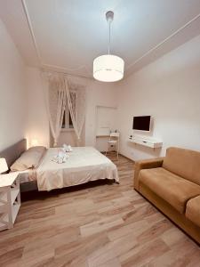- une chambre avec un lit, un canapé et une télévision dans l'établissement Appio Latino Casa by Bobo, à Rome