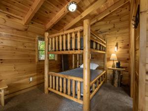 a bedroom with two bunk beds in a log cabin at Bear Necessities, 1 Bedroom, Sleeps 8, Pool Table, Arcade, WiFi, Pets in Gatlinburg