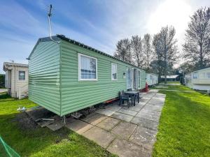 a green tiny house with a table and chairs at Lovely 8 Berth Caravan At Southview Holiday Park Near Skegness Beach Ref 33031cl in Skegness