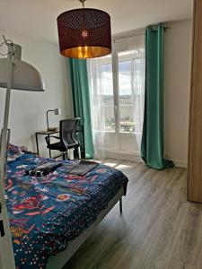 - une chambre avec un lit, une table et une fenêtre dans l'établissement Grand lumineux appartement près de Paris de 4 chambres, 80 m², à Cergy