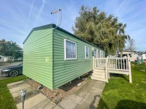 a green and white tiny house in a yard at Lovely Dog Friendly Caravan At Southview Holiday Park In Skegness Ref 33053s in Skegness