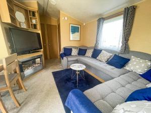 uma sala de estar com um sofá e uma televisão em Lovely Dog Friendly Caravan At Southview Holiday Park In Skegness Ref 33053s em Skegness