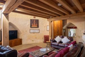 a living room with leather couches and a tv at Lendal Tower in York