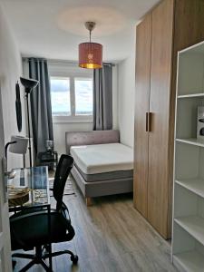 - une chambre avec un lit, un bureau et une chaise dans l'établissement Grand lumineux appartement près de Paris de 4 chambres, 80 m², à Cergy