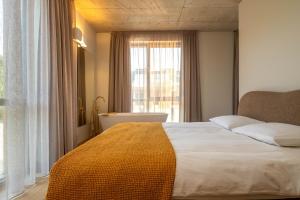 a bedroom with a large bed and a large window at Nida Boutique in Nida