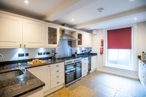 a kitchen with white cabinets and a large window at Lendal Tower in York