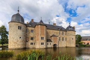 un vieux château au milieu d'une masse d'eau dans l'établissement Au chovelète, à Rochefort