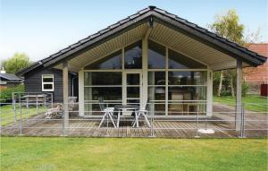 a screened in porch with a table and chairs at Amazing Home In Haderslev With 3 Bedrooms, Sauna And Wifi in Kelstrup Strand