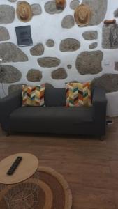 Sofá negro sentado en una sala de estar con mesa en Casa pitita, en Maspalomas